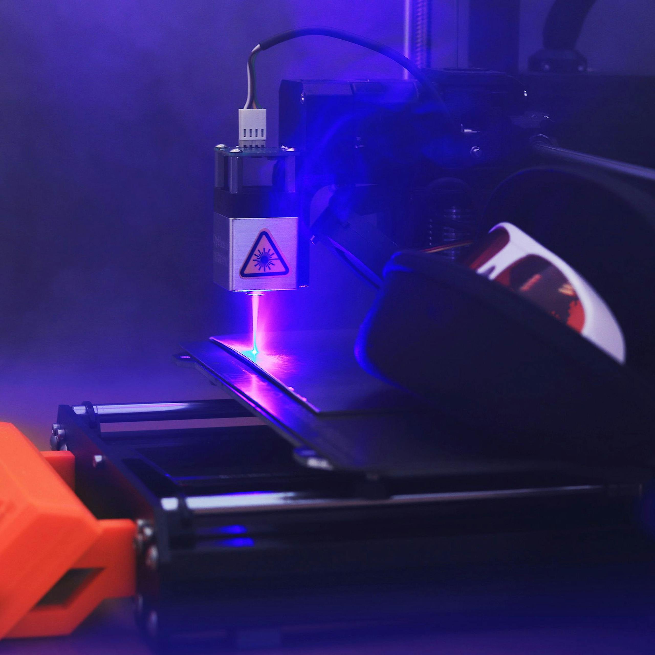 Blue laser engraving machine in action, showcasing precision cutting and technology